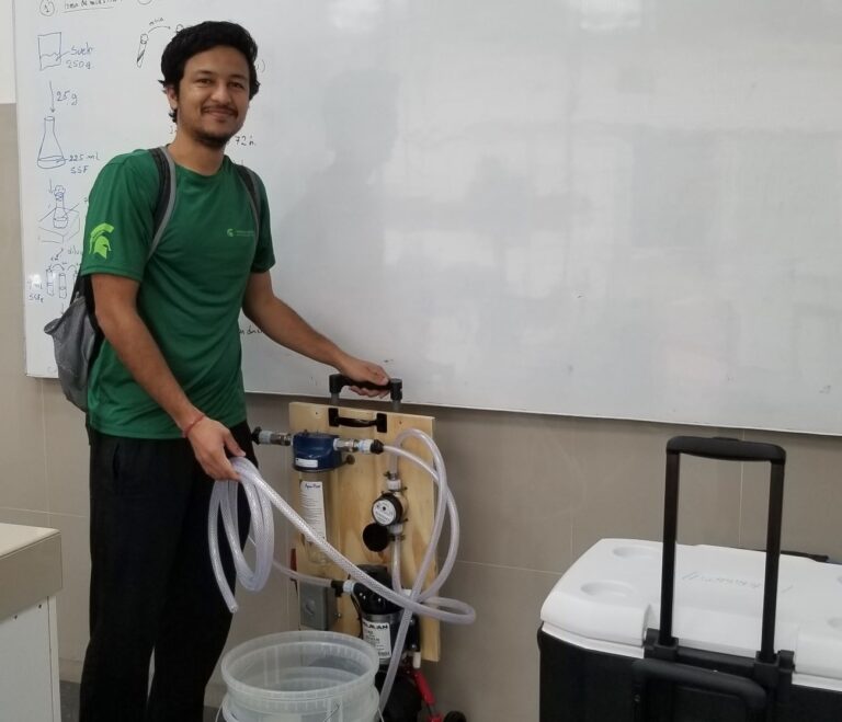 Person smiling next to the machine in the classroom