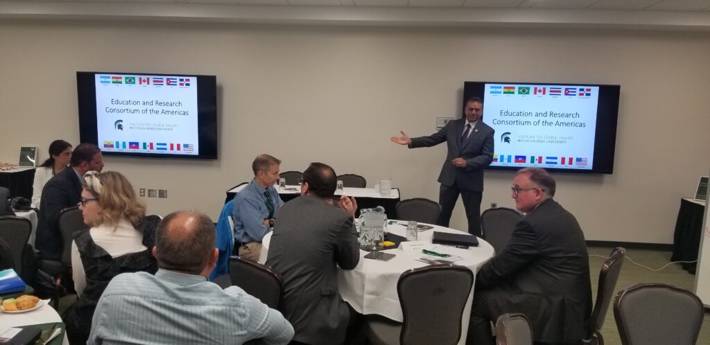 A photo from the 2019 ERCA symposium. A Latino man presenting to a room of people