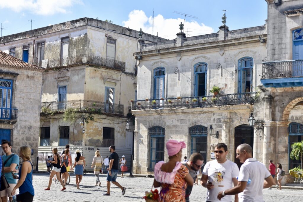 Old buildings in Cuba with blue window frames and a grey exterior