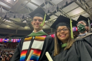 Two students smile at graduation